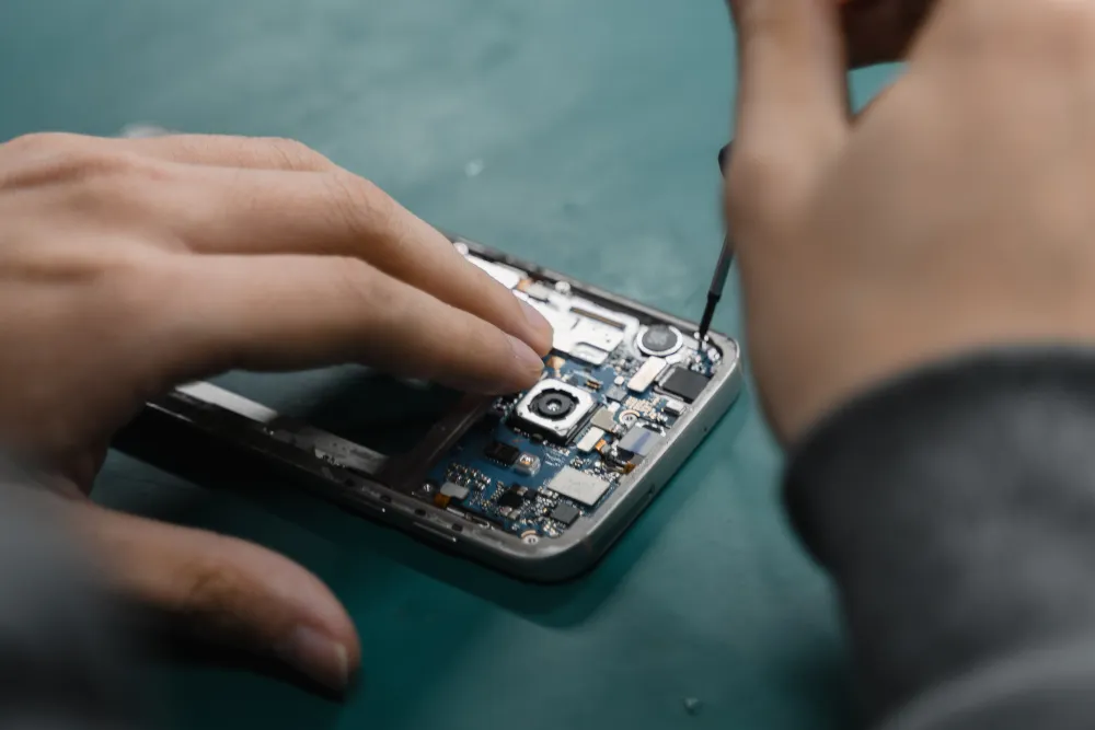 A person holding a phone showing a low battery warning