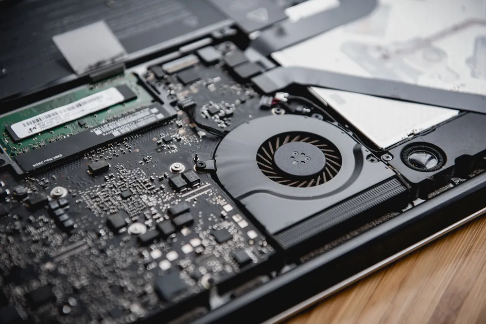 The cooling fan and heat pipes inside an opened laptop