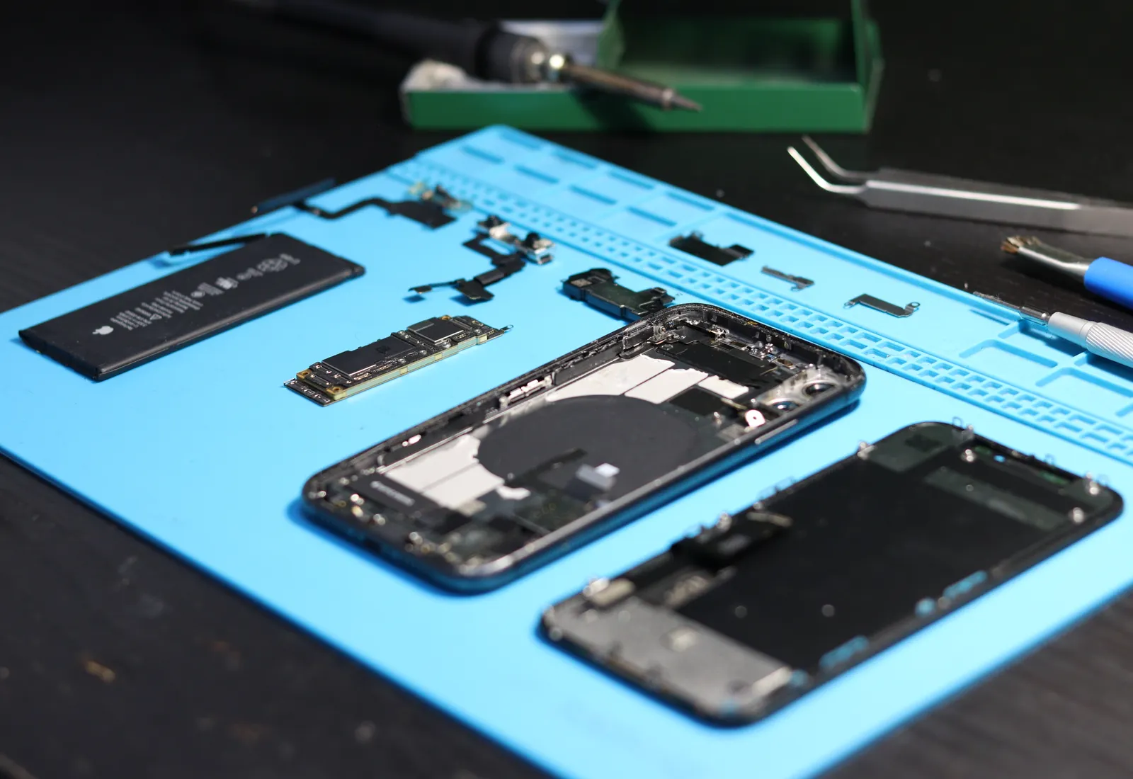 Smartphone repair tools laid out on a technician workbench