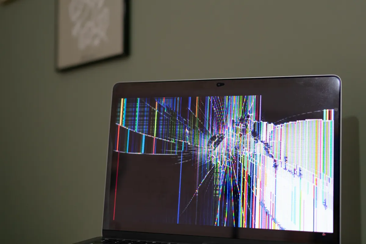 A laptop with a cracked and damaged display